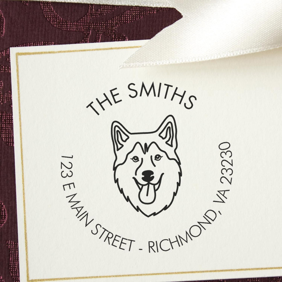 White custom stamp and seal card with black husky logo, gold border, and burgundy background.