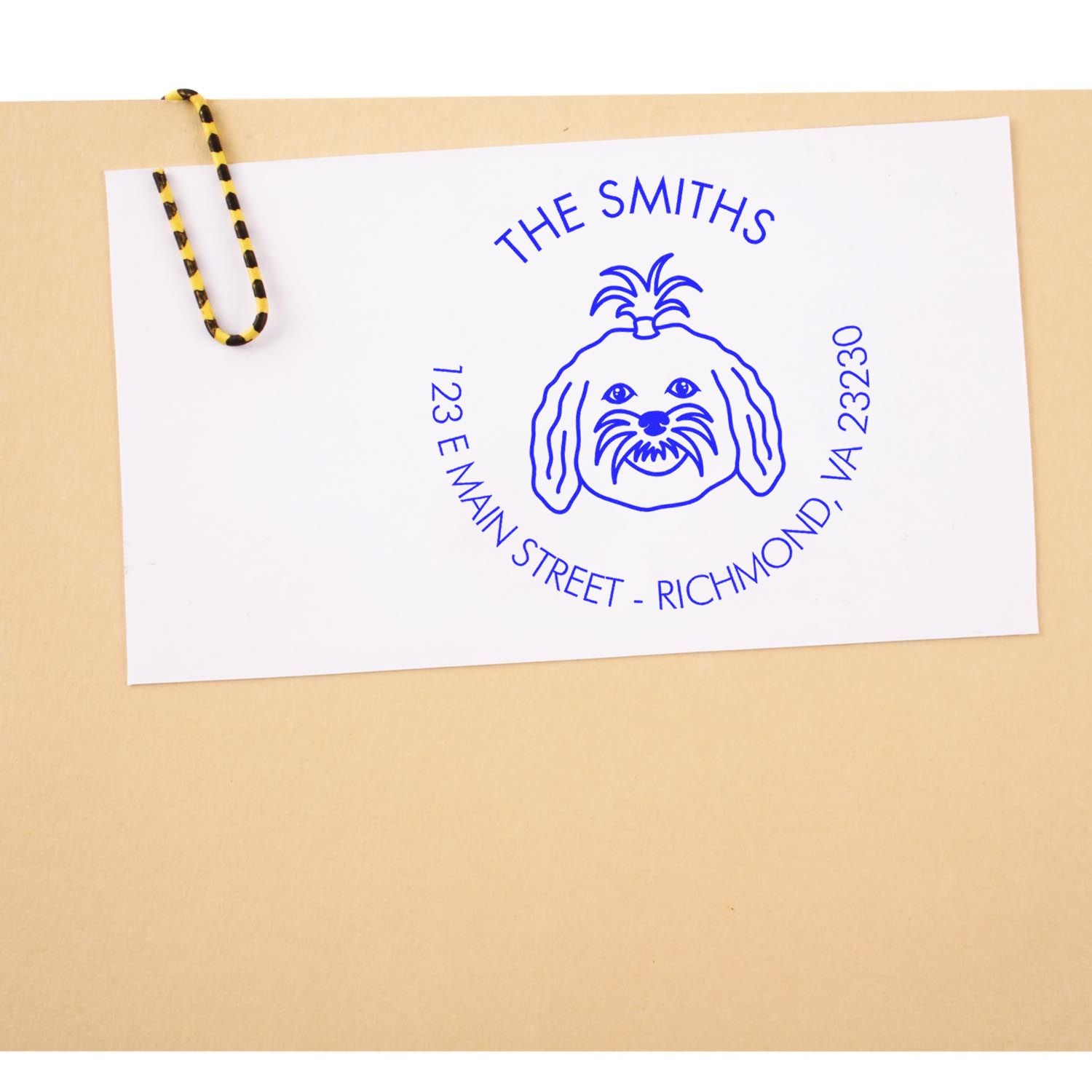 Blue custom stamp and seal with dog logo for The Smiths on white card, clipped to a tan envelope