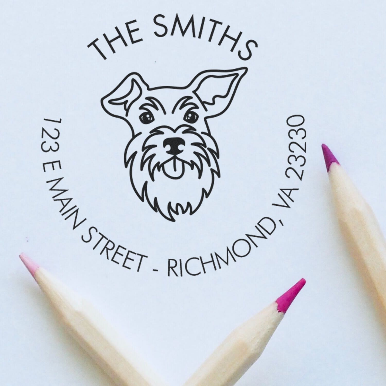 Custom wood handle Schnauzer dog rubber stamp by ESS in use, featuring a detailed Schnauzer design for home address stamping.