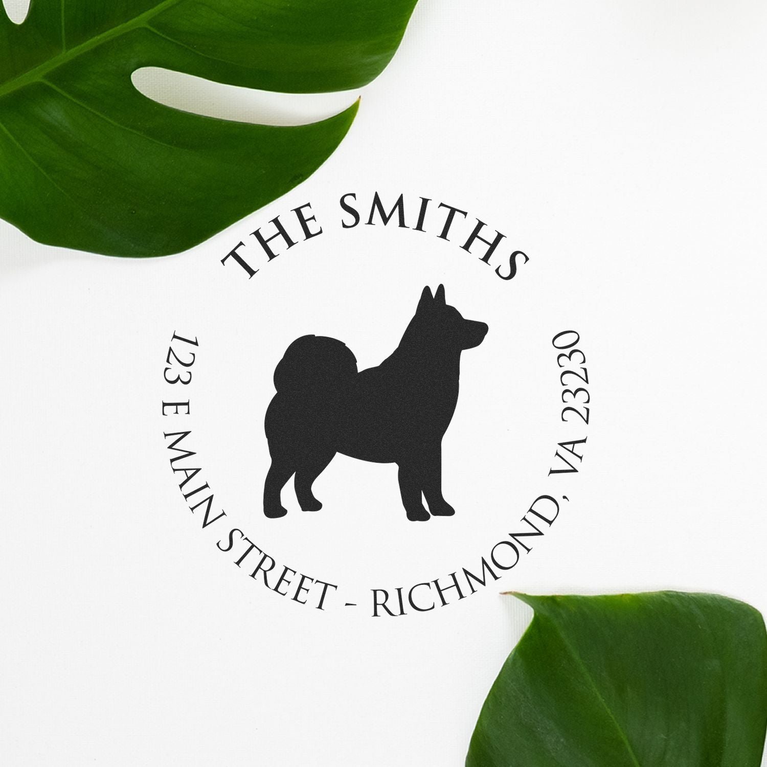 Black custom dog logo stamp seal for The Smiths, with arched text and address on white, framed by green leaves.