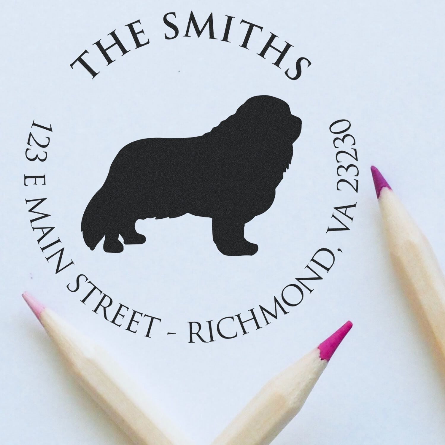 Custom black stamp and seal with bulldog silhouette, circular address text, and pink-tipped pencils on white paper.