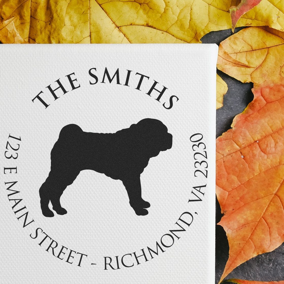 White custom stamp seal with black dog silhouette, THE SMITHS text, and address on a textured white card over autumn leaves.