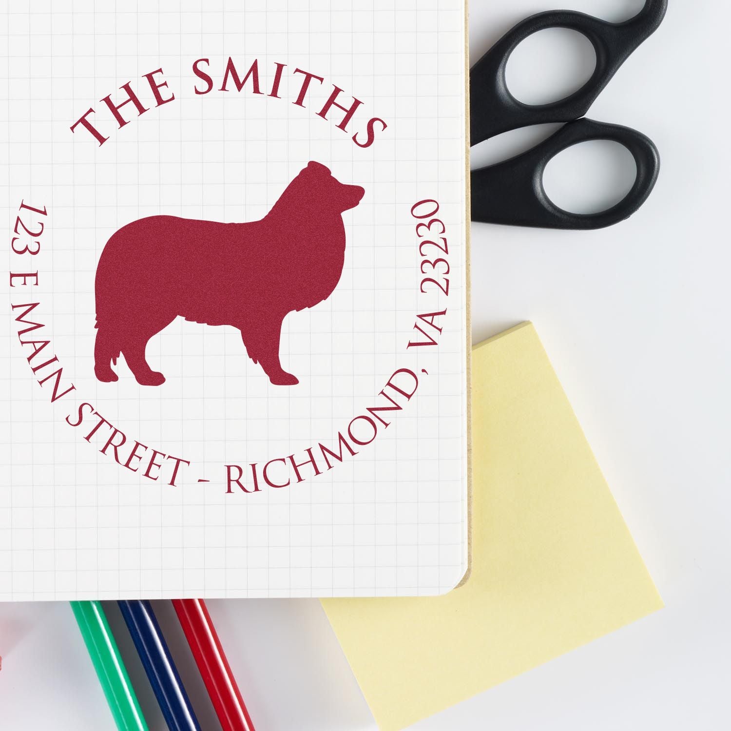 Maroon bear address stamp and seal for The Smiths, 123 E Main Street, Richmond VA 23230, with black scissors and yellow note