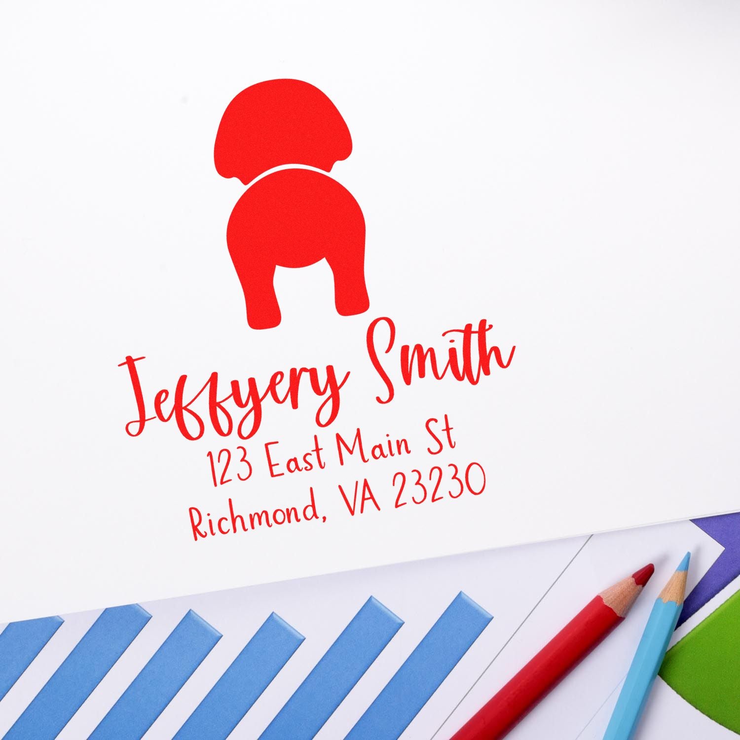 Red custom stamp seal for Jeffrey Smith with address, on white paper beside blue envelopes and colored pencils.