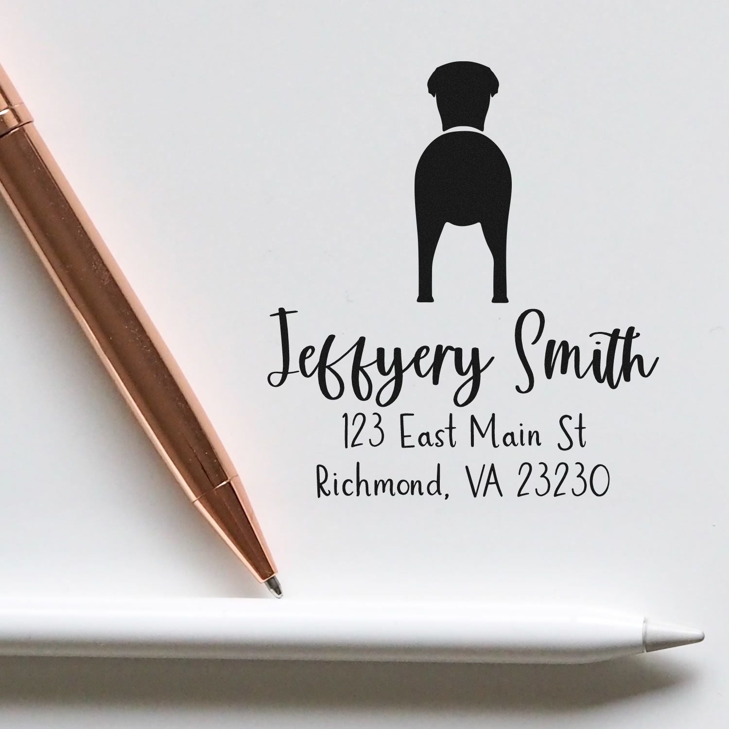 Greyhound dog-shaped rubber address stamp with wood handle, custom-made by ESS, in use for mailing.