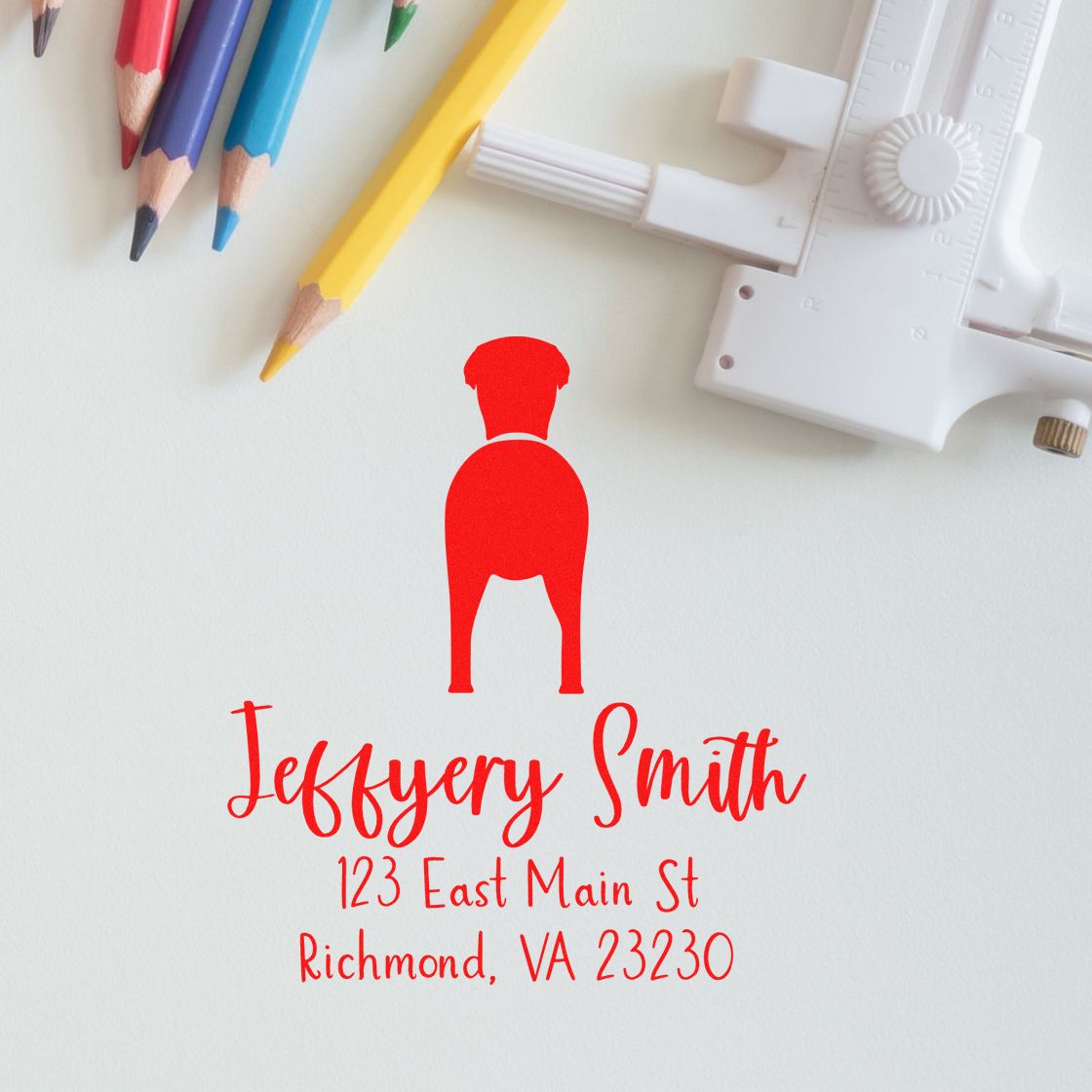 Grayhound dog-shaped rubber address stamp with wooden handle, custom-made by ESS, shown in use on paper.
