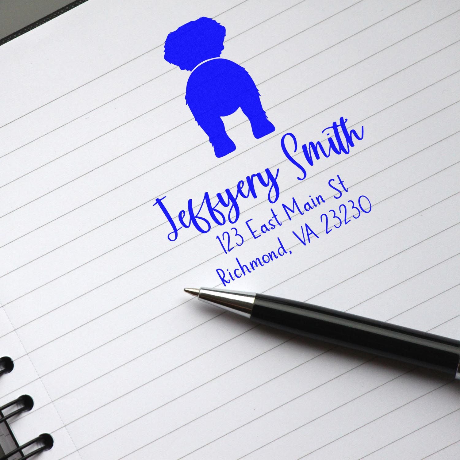 Blue custom address stamp and seal with dog logo, Jeffery Smith name, and address on lined notebook paper.