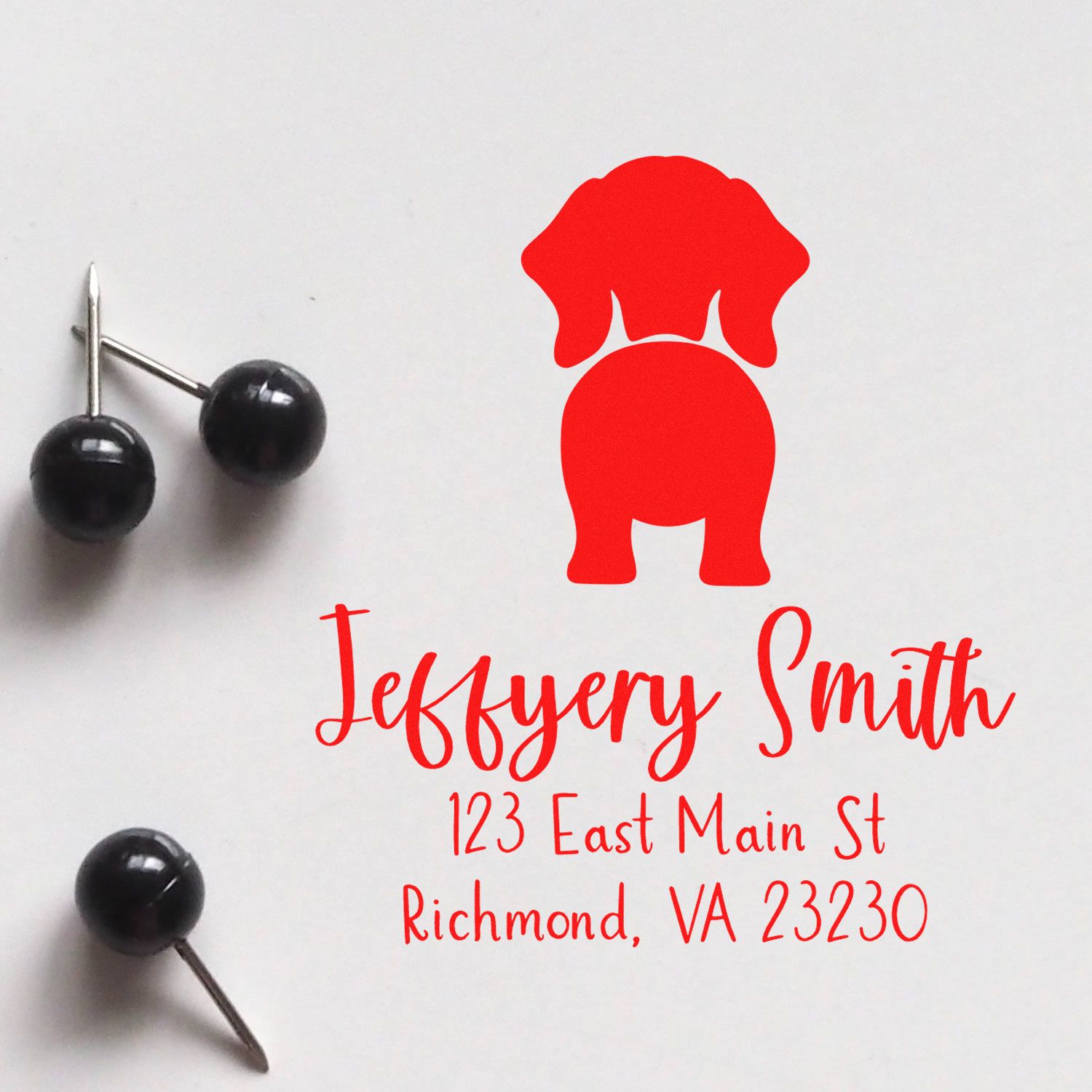 Red custom dog logo stamp and seal with black stamp tools, displaying Jeffrey Smith address on white paper.