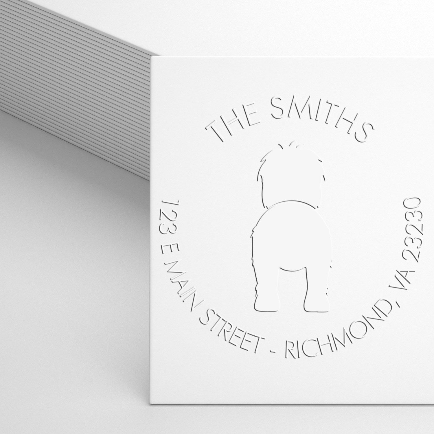 White embossed custom stamp seal for The Smiths, with address details and a simple logo on a clean gray-white background.