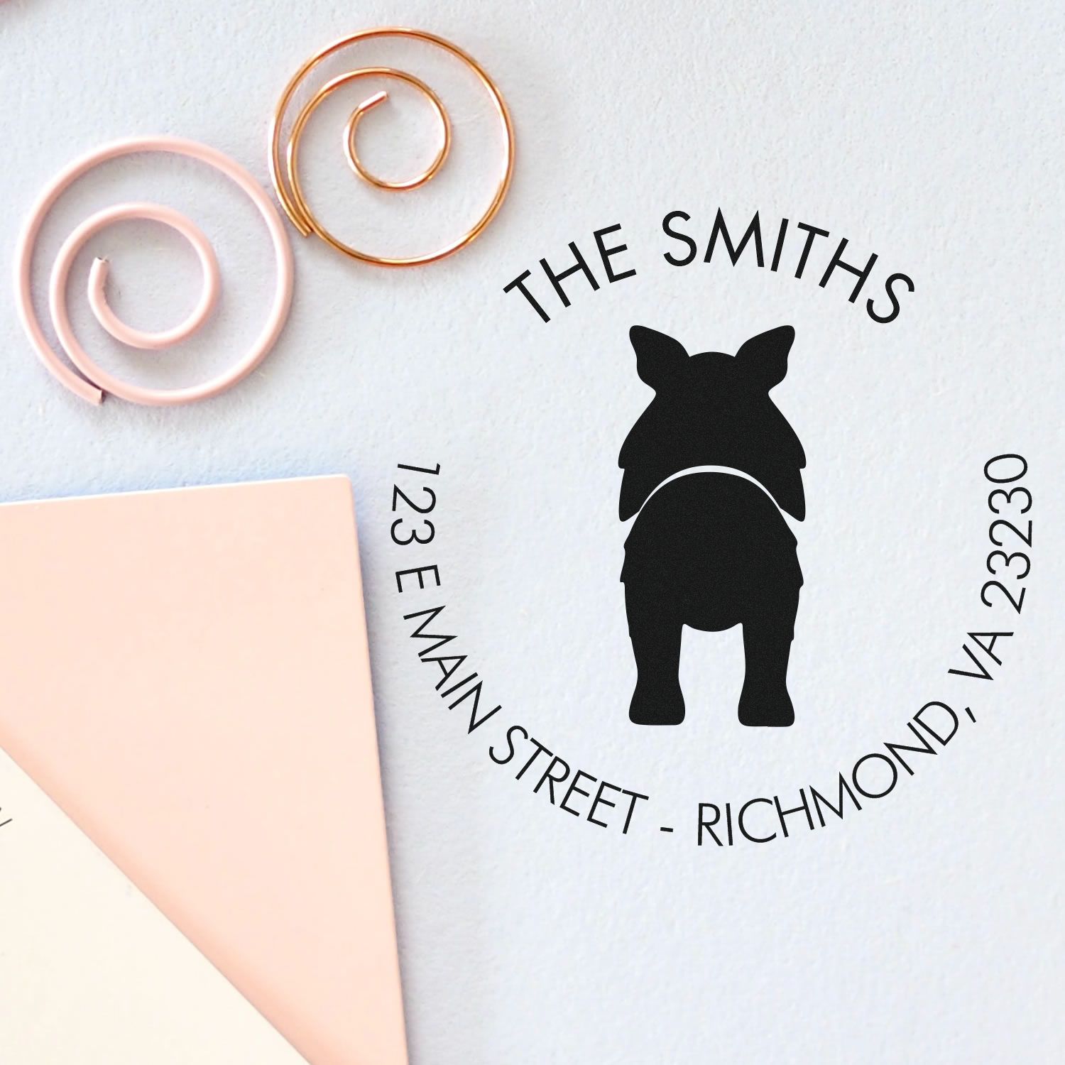 Custom black pig address stamp with circular Smiths return address, beside blush pink and gold wax seal coils on white paper