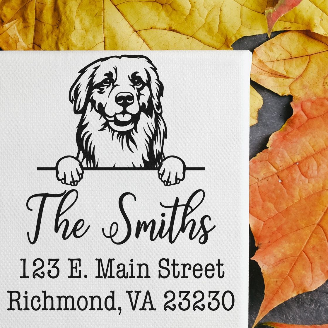 Black custom address stamp and seal with dog illustration, The Smiths, and 123 E. Main Street on white, over autumn leaves.