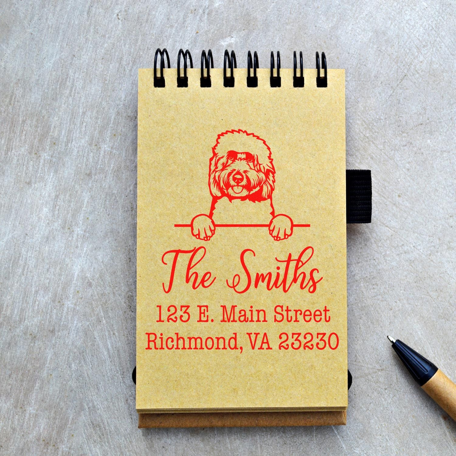 Custom red dog stamp and seal on yellow spiral notepad with The Smiths name and address.