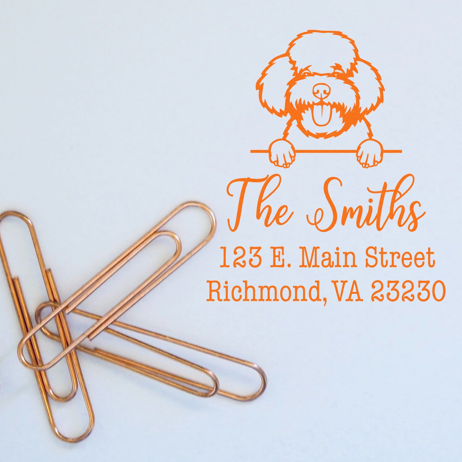Orange custom address stamp and seal with poodle logo, The Smiths, and Richmond, VA text on a light blue background.