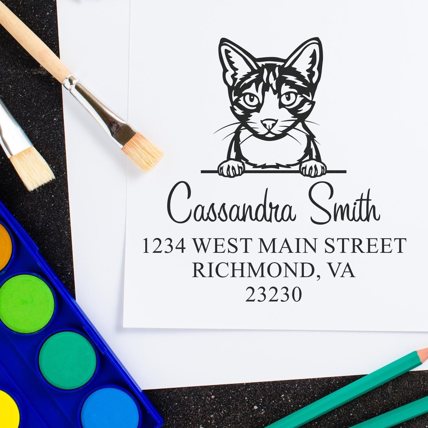 Black cat address stamp and seal design with name, Richmond VA address, paintbrushes, and watercolor paints.