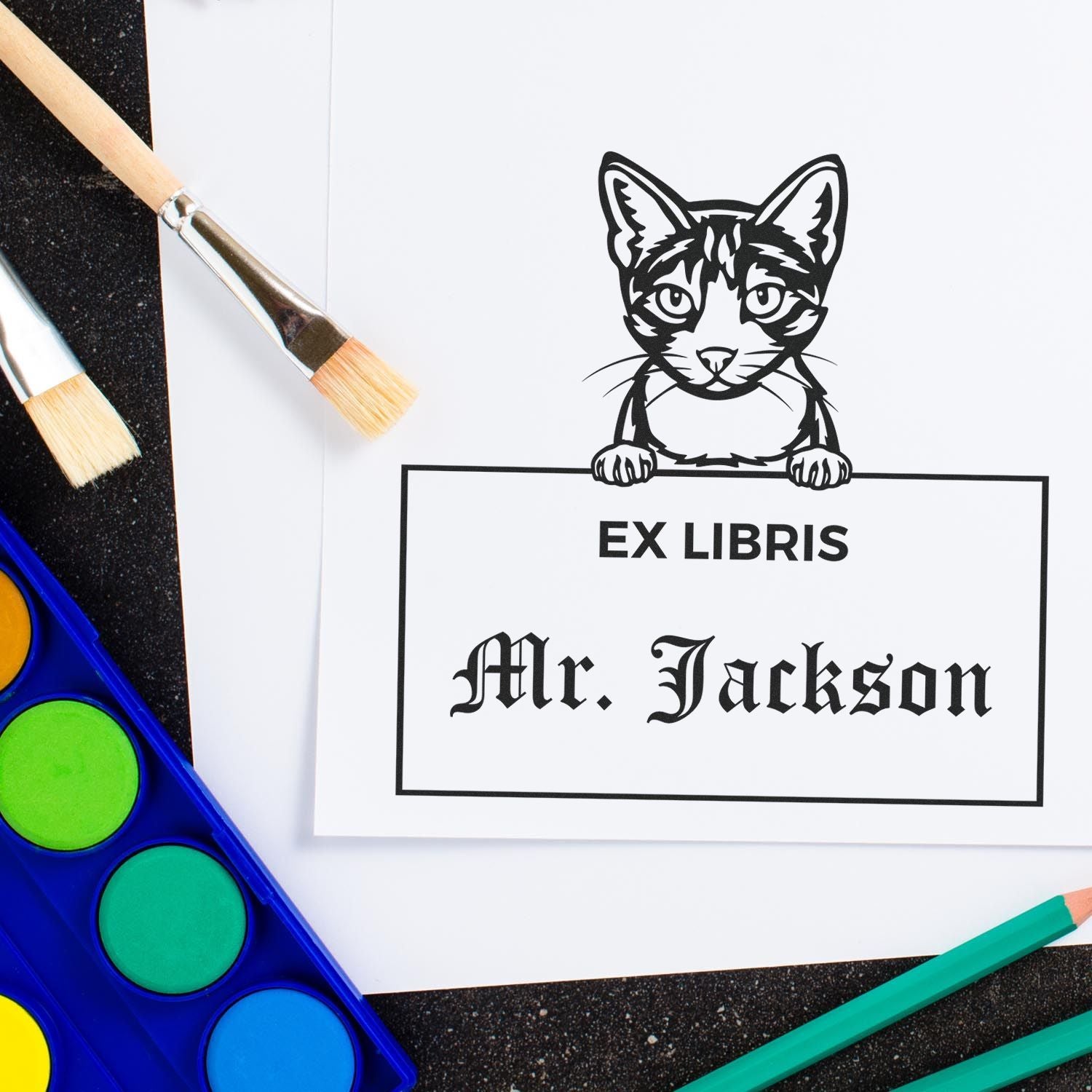 Custom stamp and seal ex libris bookplate with cat illustration, Mr. Jackson text, and art brushes beside colorful paint palette.
