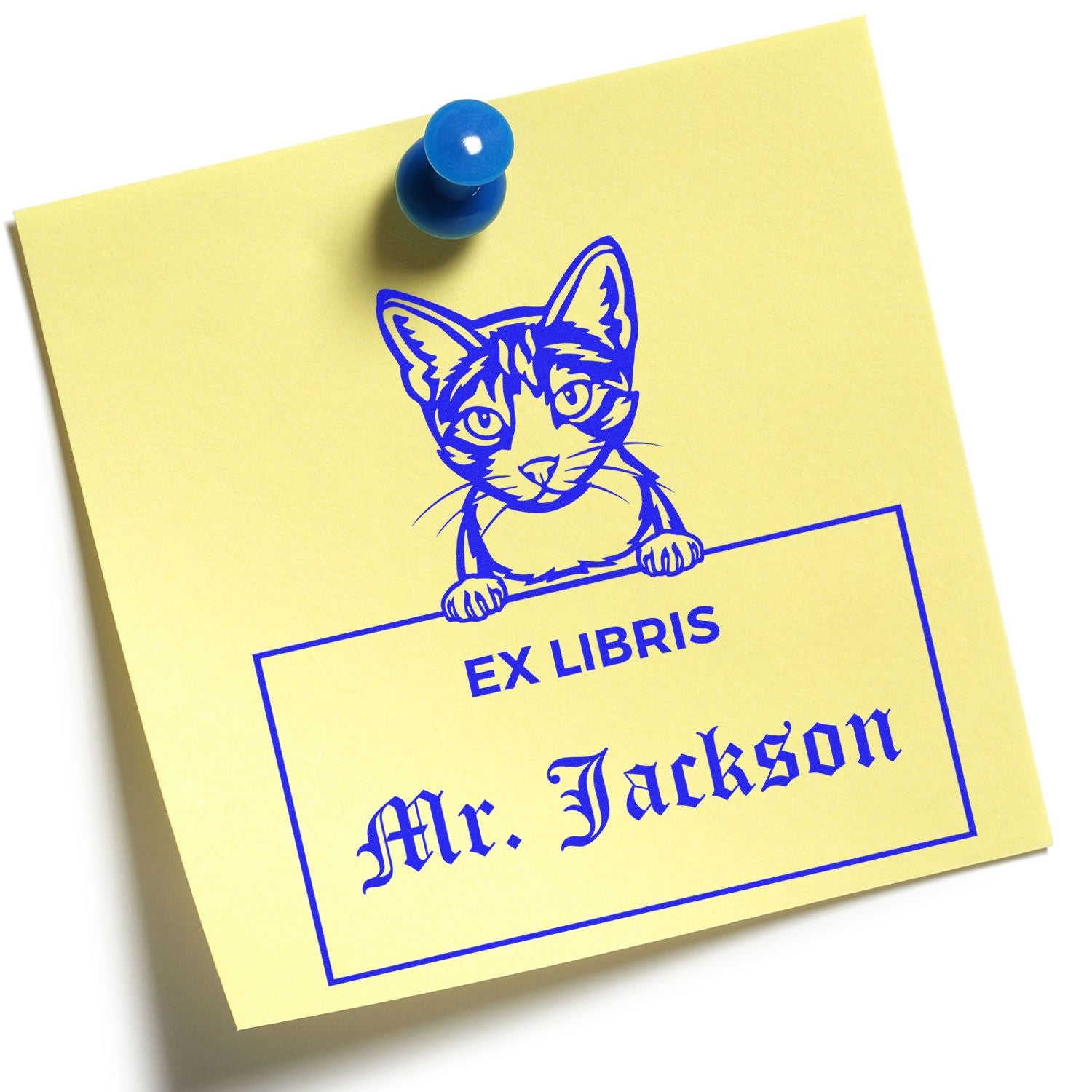 Yellow sticky note with blue cat ex libris book stamp, Mr. Jackson, pinned by a blue pushpin.