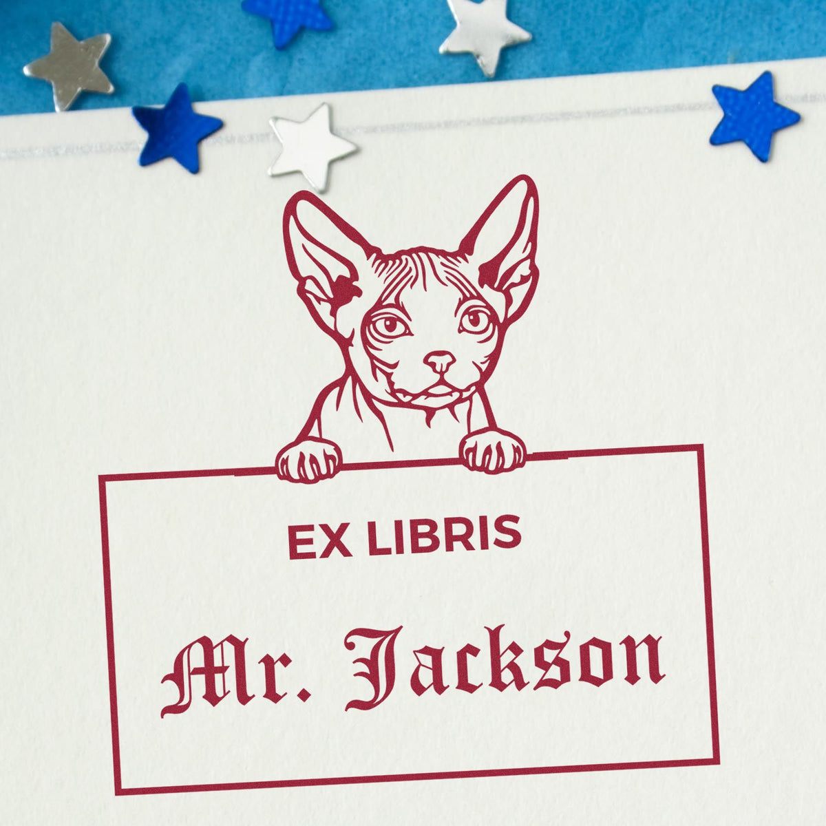 Red ex libris stamp seal with cat illustration and Mr. Jackson text on white paper, accented by blue and silver stars.