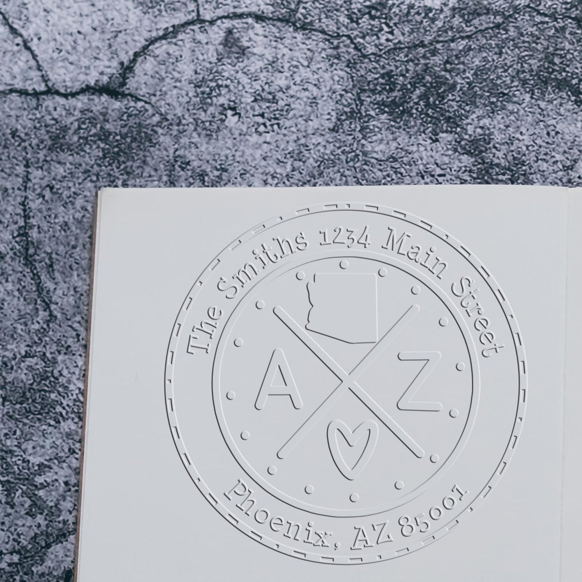 Embossed white address stamp seal with circular logo, AZ outline, initials A Z, and The Smiths 1234 Main Street Phoenix, AZ.