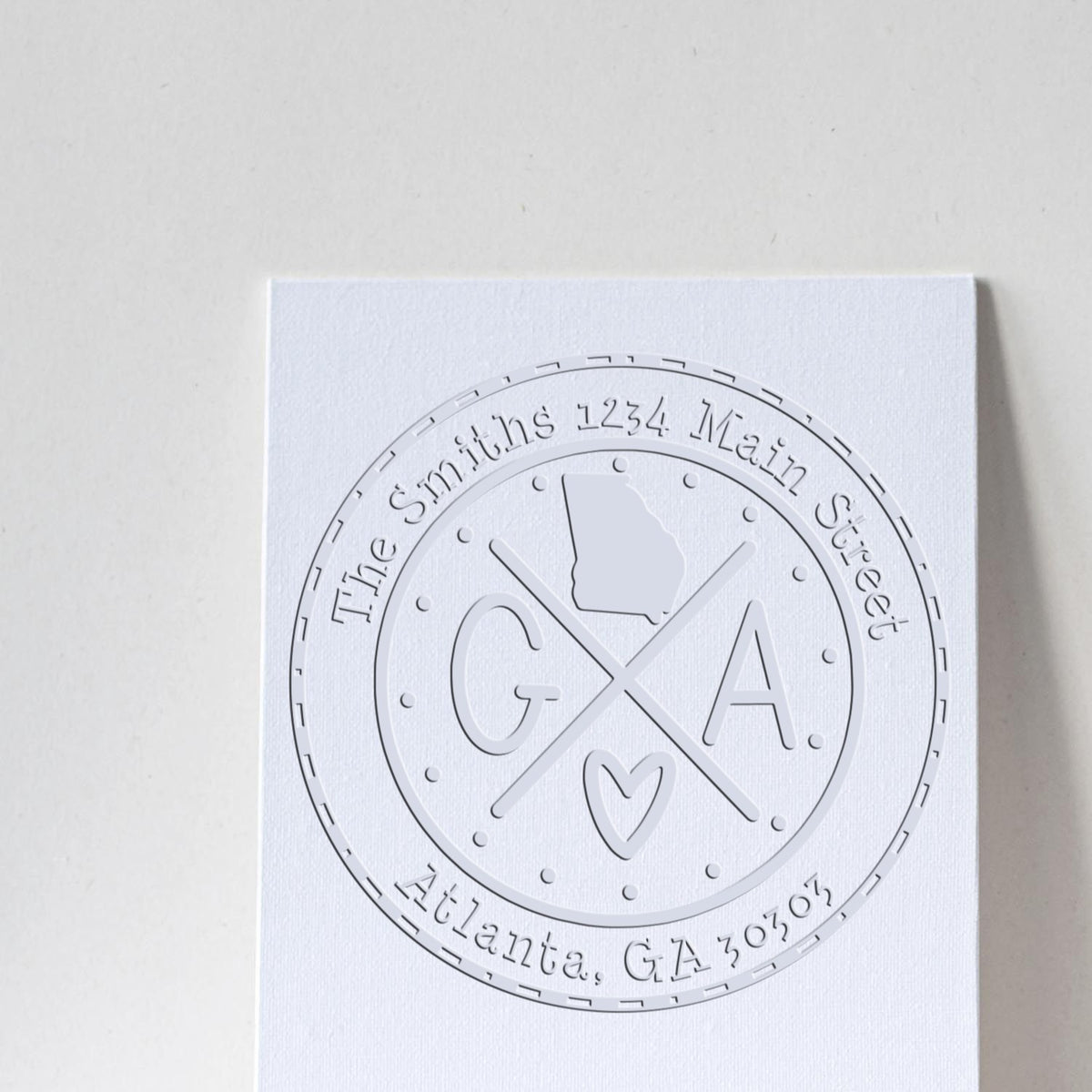 White embossed custom seal stamp with GA monogram, The Smiths address and Atlanta, GA on textured card.