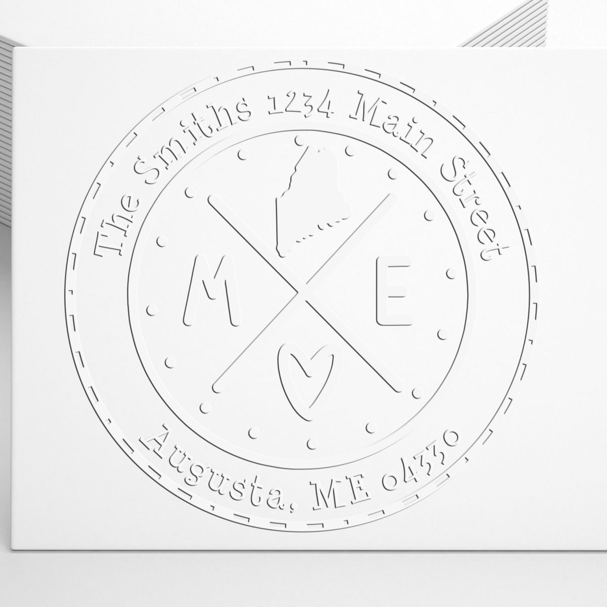 White embossed circular custom stamp seal with The Smiths, address text, and M/E monogram with heart.