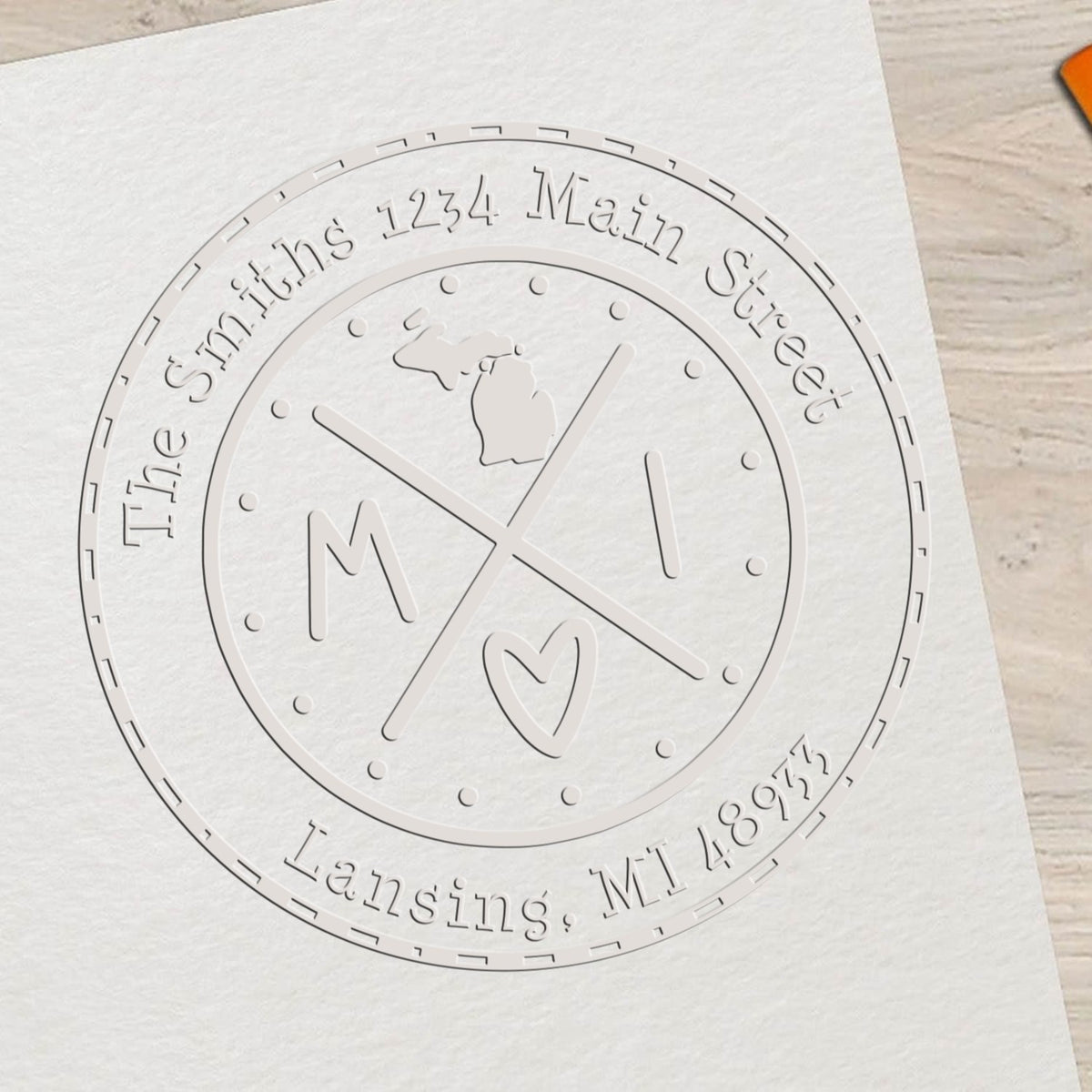 Embossed white circular stamp seal with Michigan outline, crossed lines, and The Smiths 1234 Main Street, Lansing, MI 48922
