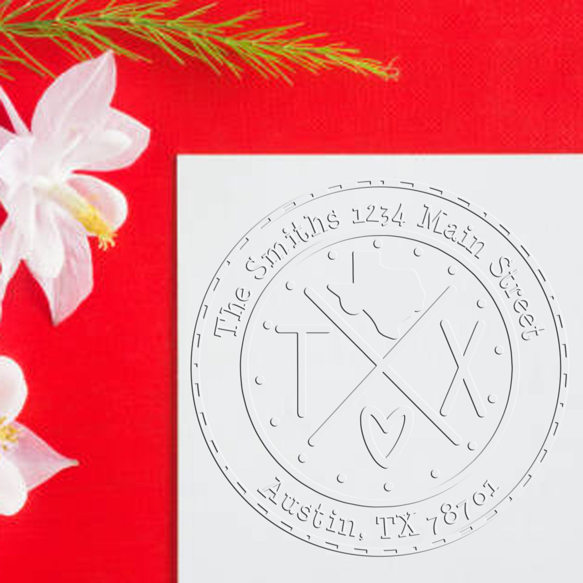 White embossed custom stamp seal on a white card, set against a bright red background with white flowers.