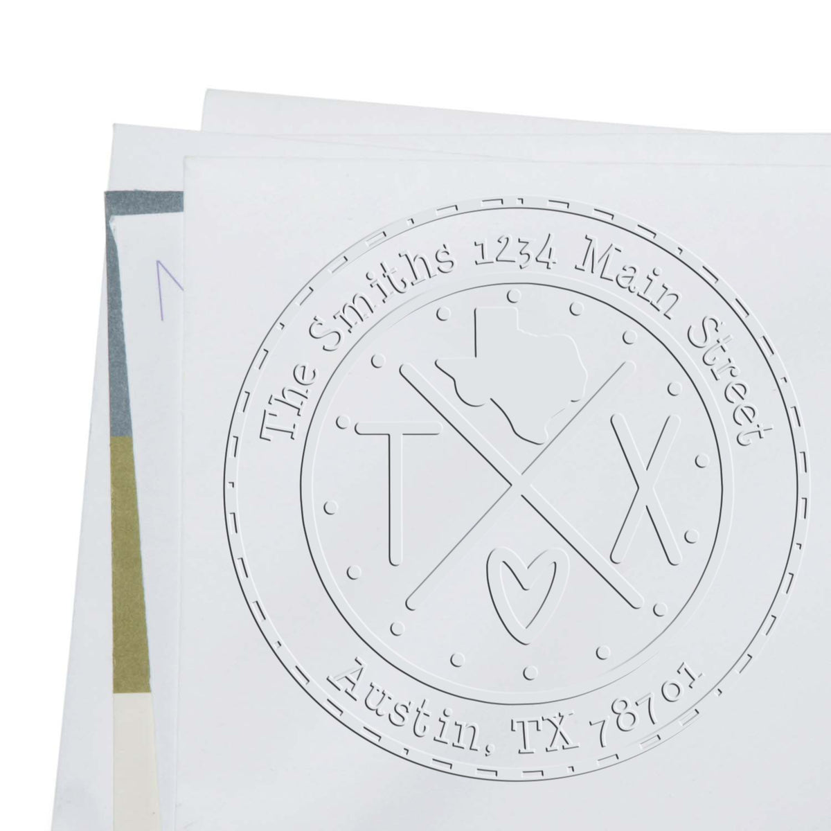 White embossed custom stamp and seal cards with circular TX monogram and address text on a clean white background.
