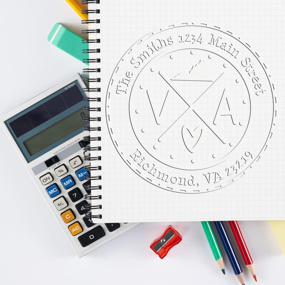 Embossed white company seal stamp on graph notebook with calculator, mint eraser, colorful pencils, and sharpener.