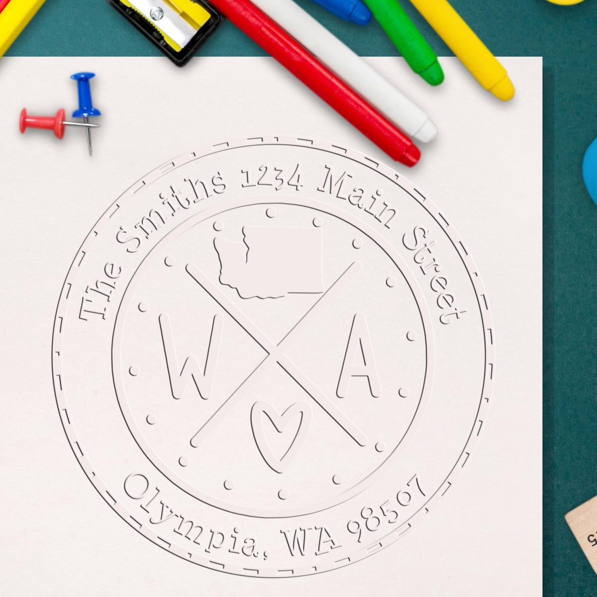 Embossed round stamp and seal template on white paper, with red, blue, green and yellow pens around it.
