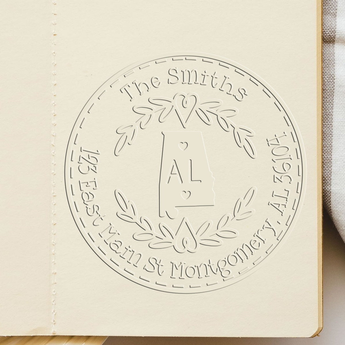Custom embossed seal stamp on cream paper, featuring Alabama outline, laurel wreath, The Smiths, and subtle silver-gray detailing.