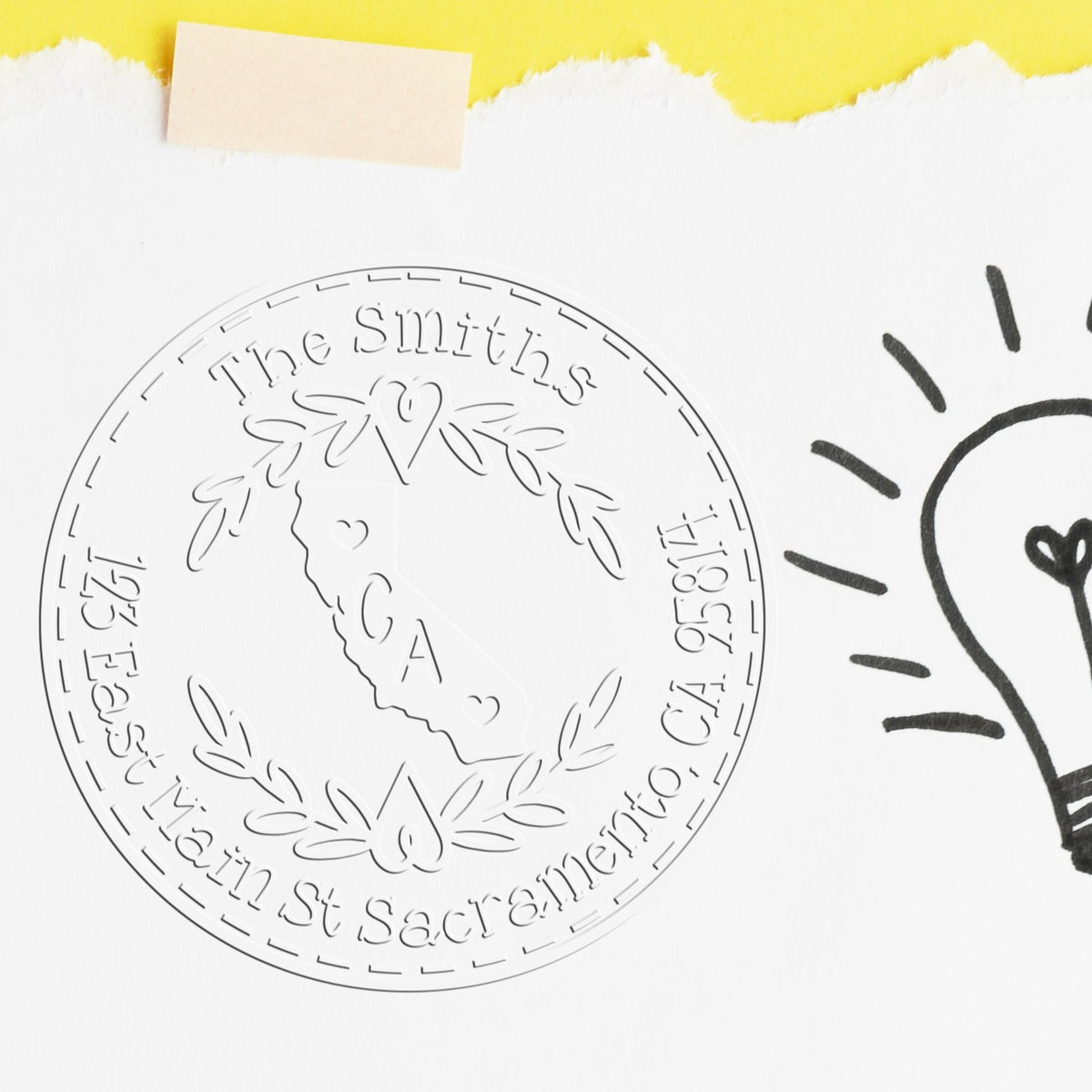 Embossed circular custom stamp seal for The Smiths, CA, on white paper with yellow torn edge and beige tape.