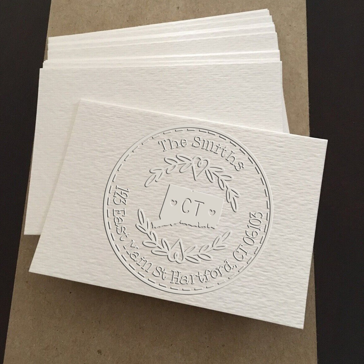 Trodat State Love Stamps CT Custom Return Address Embosser featuring a state-shaped seal in use on paper.