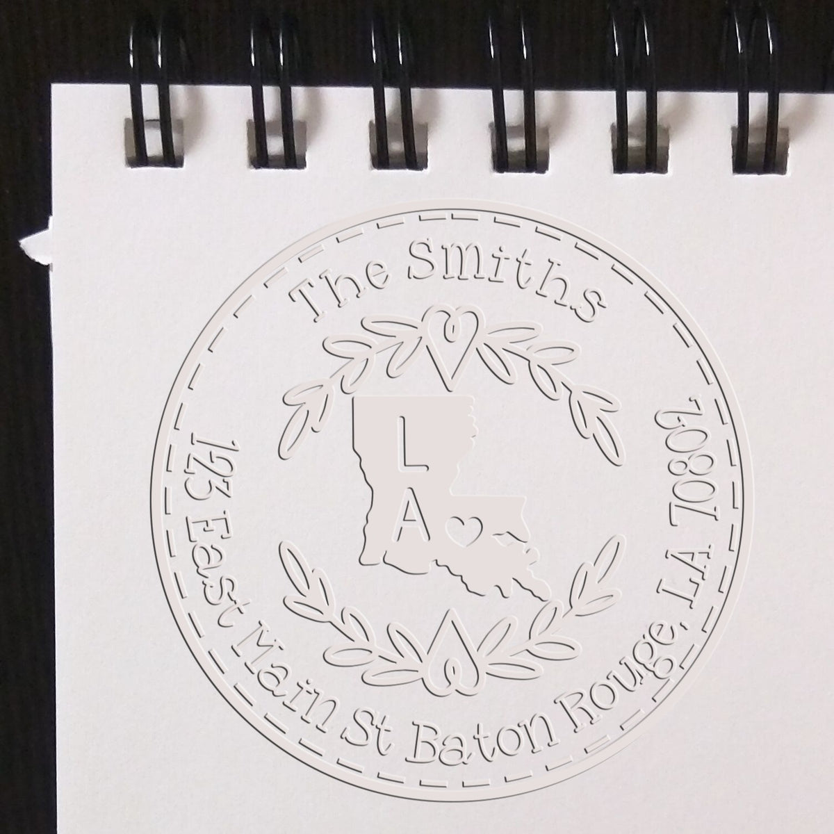 Trodat State Wreath LA Custom Address Return Seal Embosser with State Love Stamps design in use on paper.