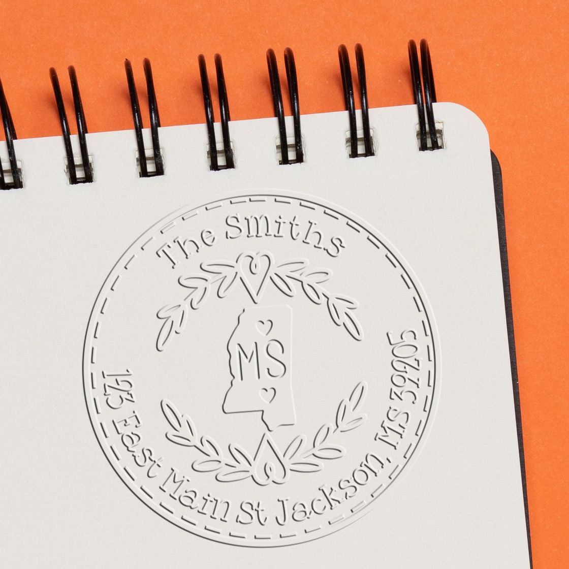 Trodat State Love Stamps address return embossing stamp featuring a custom state wreath design in use.