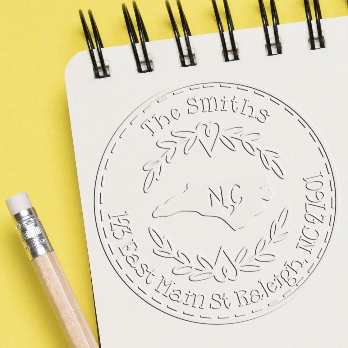 Trodat State Love Stamps NC custom mail address embossed seal in use, featuring state outline and decorative design.