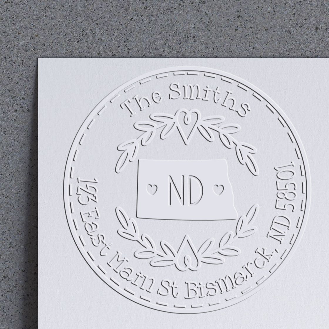 Trodat State Love Stamps ND custom mail address embossing seal in use, featuring a state-shaped design on paper.