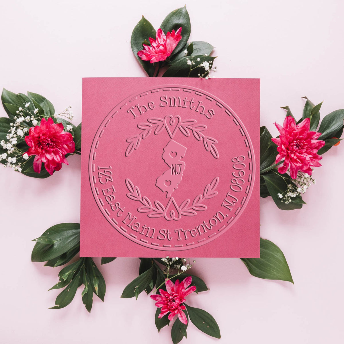 Pink custom embossing seal with The Smiths and New Jersey outline, framed by green leaves and bright magenta flowers.
