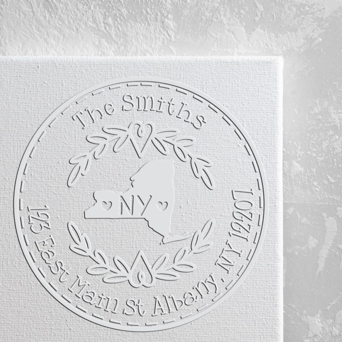 White embossed circular stamp seal for The Smiths, featuring NY outline, hearts, laurel wreath, and Albany address.