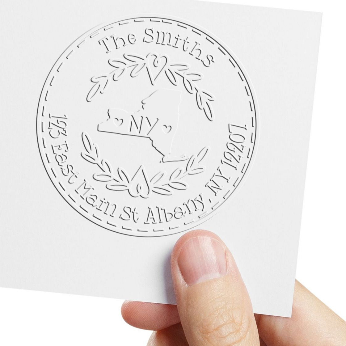 Embossed white circular stamp seal for The Smiths, with NY outline, laurel wreath and Albany, New York address.