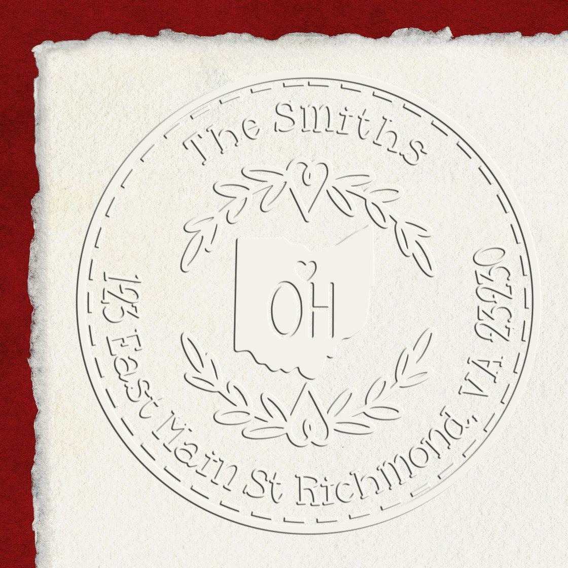 Embossed circular stamp seal on white textured paper, with The Smiths and East Main St Richmond, VA, over a red background.