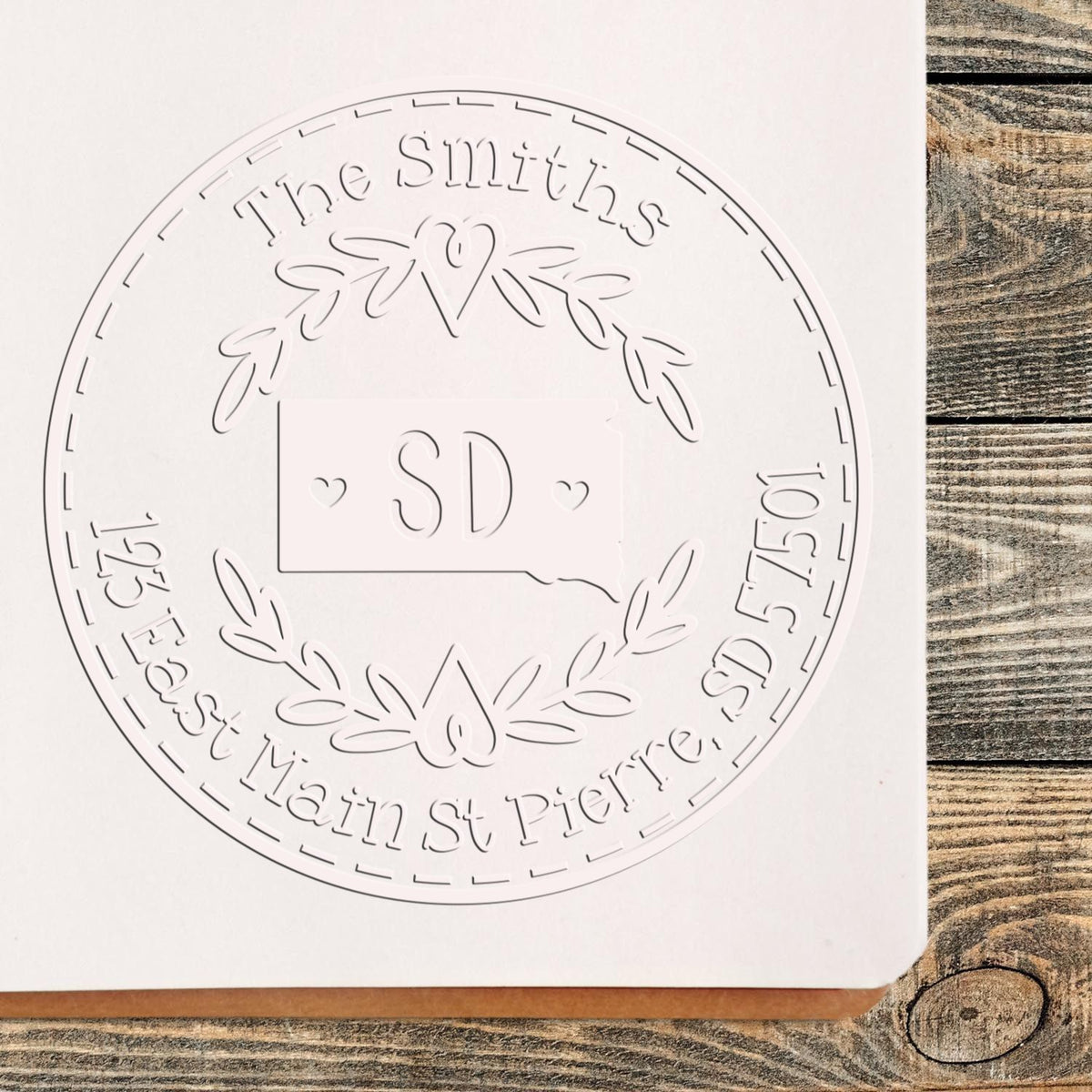 Trodat State Love Stamps SD custom name and address embosser seal in use, featuring a decorative state design and embossed text.