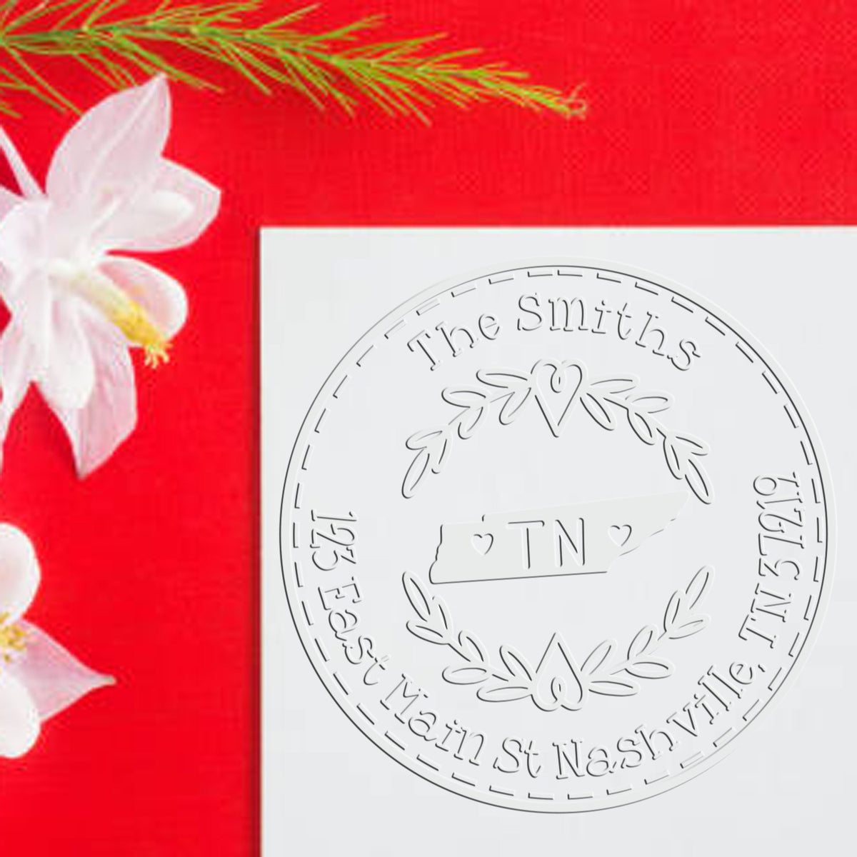 Embossed white circular family stamp seal on red background, with floral wreath, TN center, and The Smiths around the edge.