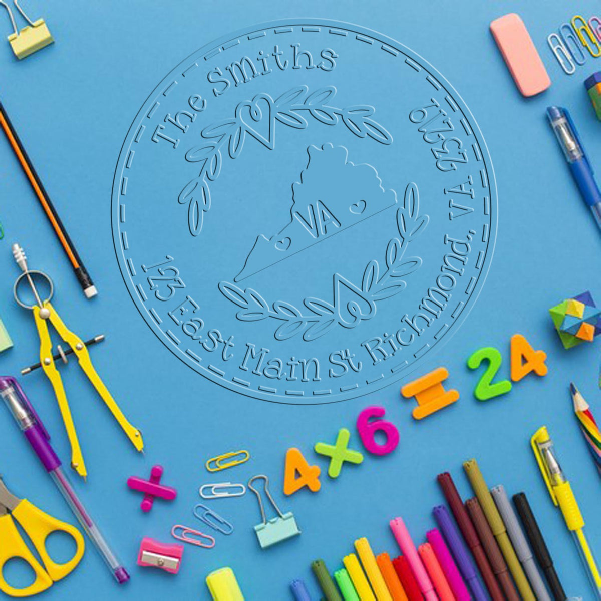 Blue custom stamp and seal product with embossed circular crest and Virginia outline, framed by colorful school supplies.