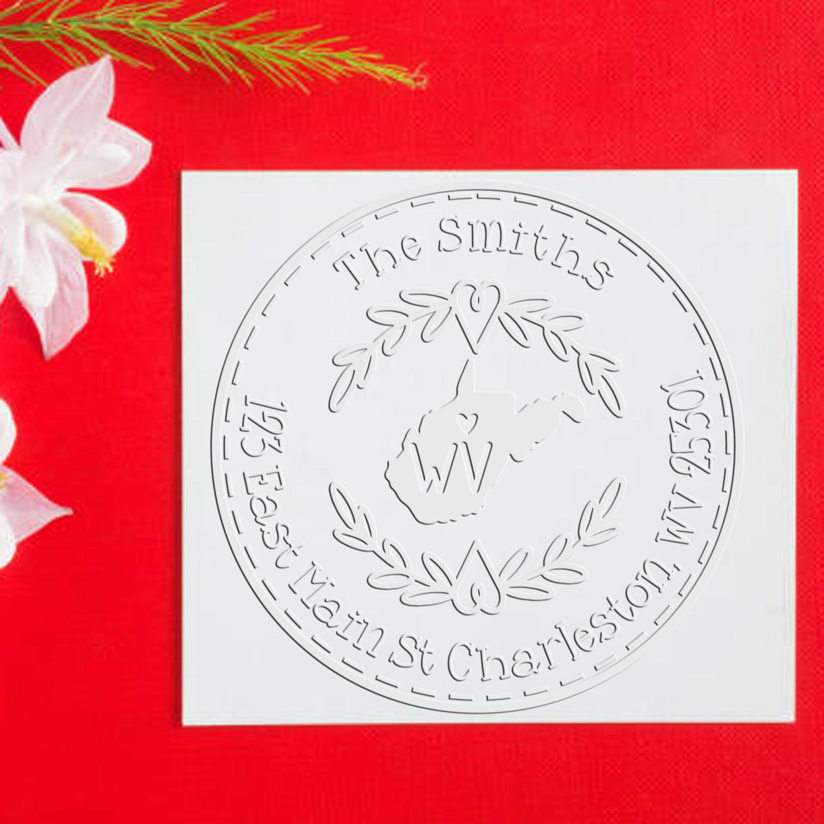 White round embossed custom stamp seal with The Smiths and West Virginia outline on bright red background with white flower