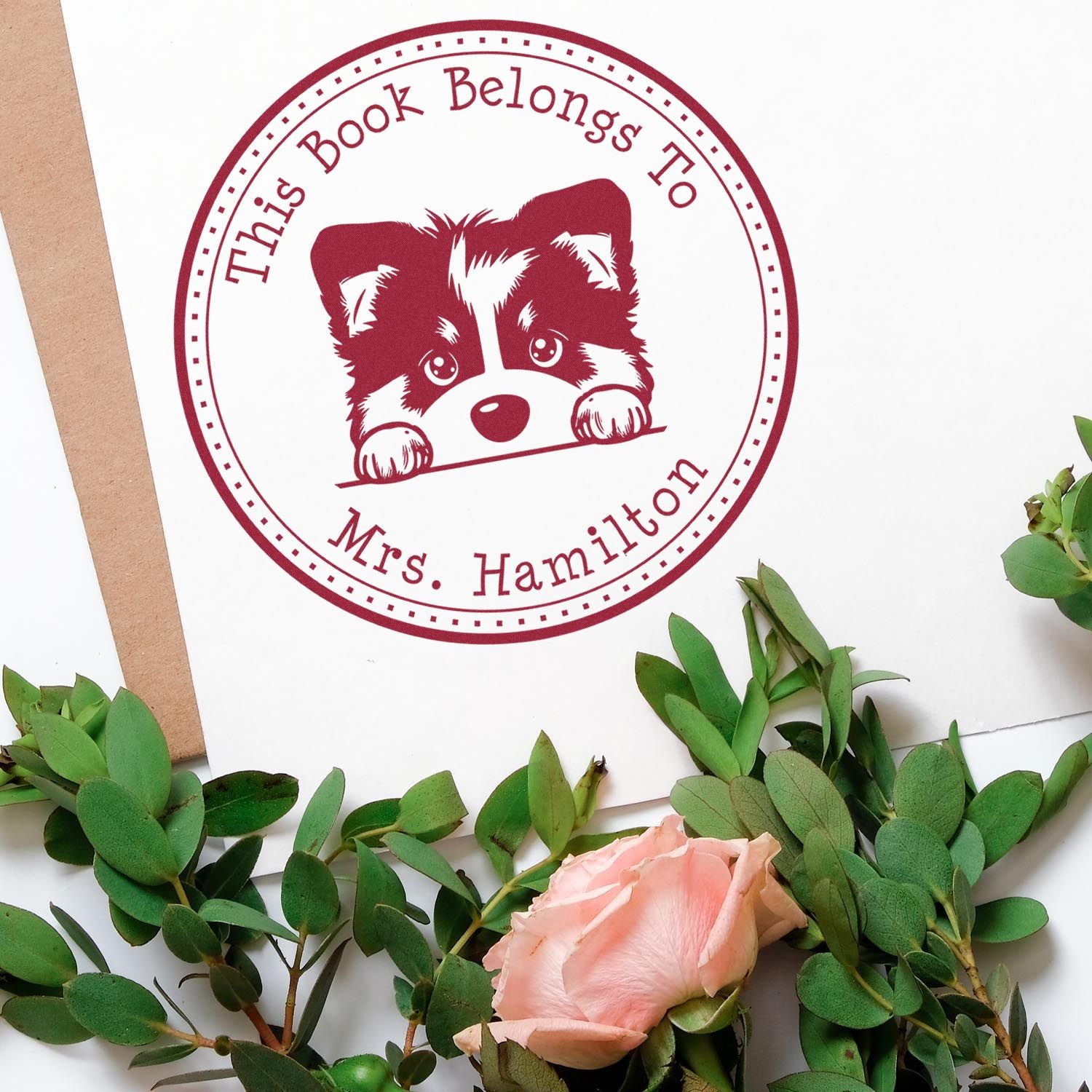 Maroon custom bookplate stamp seal with raccoon, reading This Book Belongs To Mrs. Hamilton on white paper