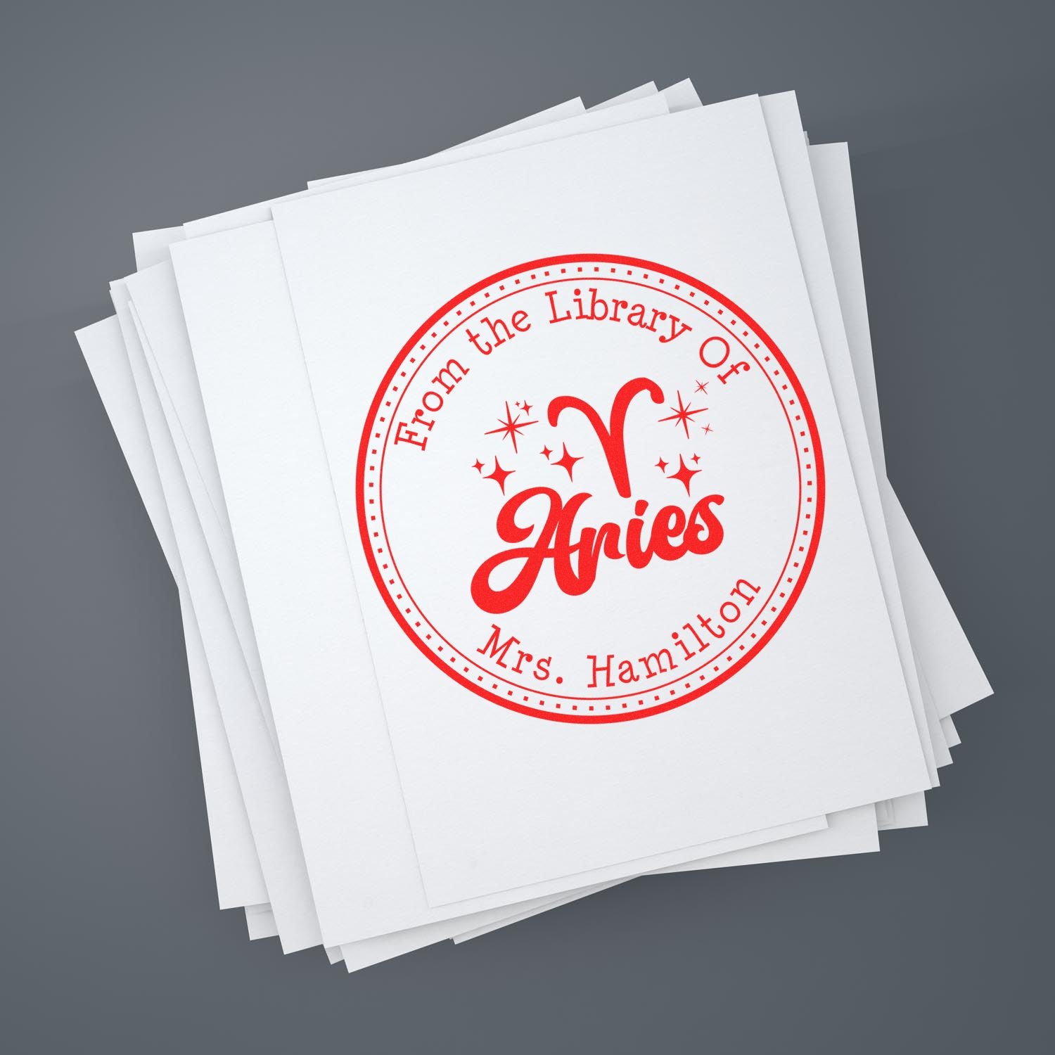 Stack of white papers with a red circular library seal stamp reading Aries and Mrs. Hamilton.