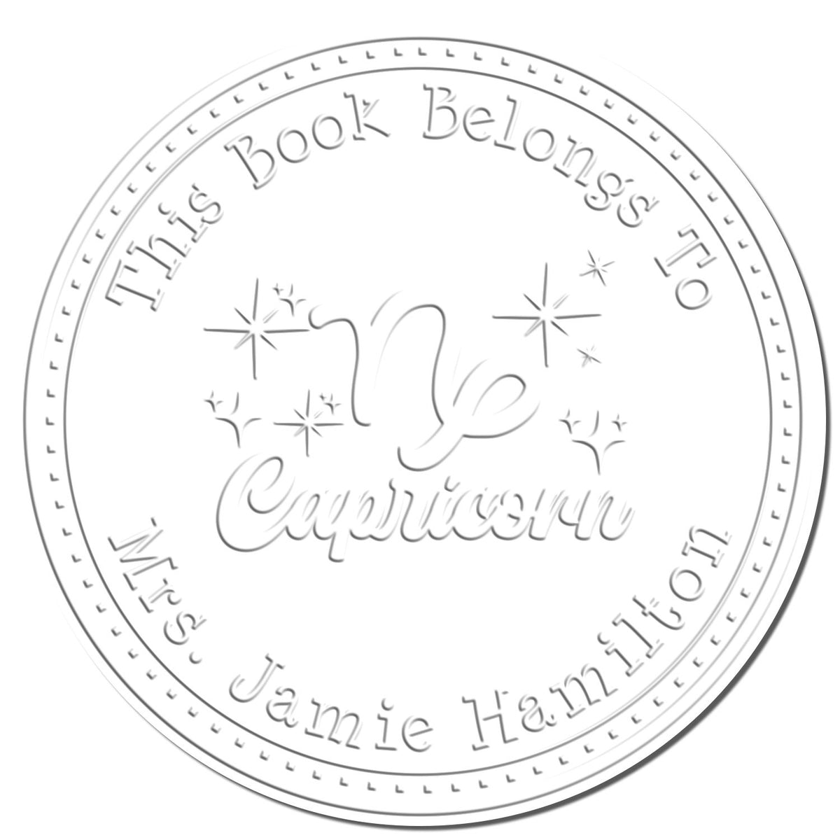 Shiny Capricorn zodiac symbol personalized book embosser with scripted font, showing the embossed seal on paper.
