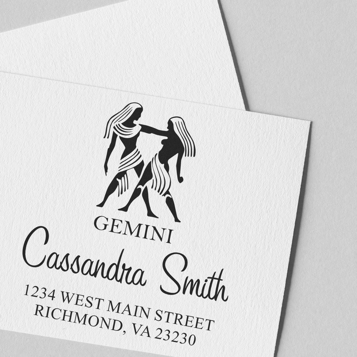 Black Gemini stamp and seal with twin figures, Cassandra Smith name, and Richmond, VA address on white textured paper.