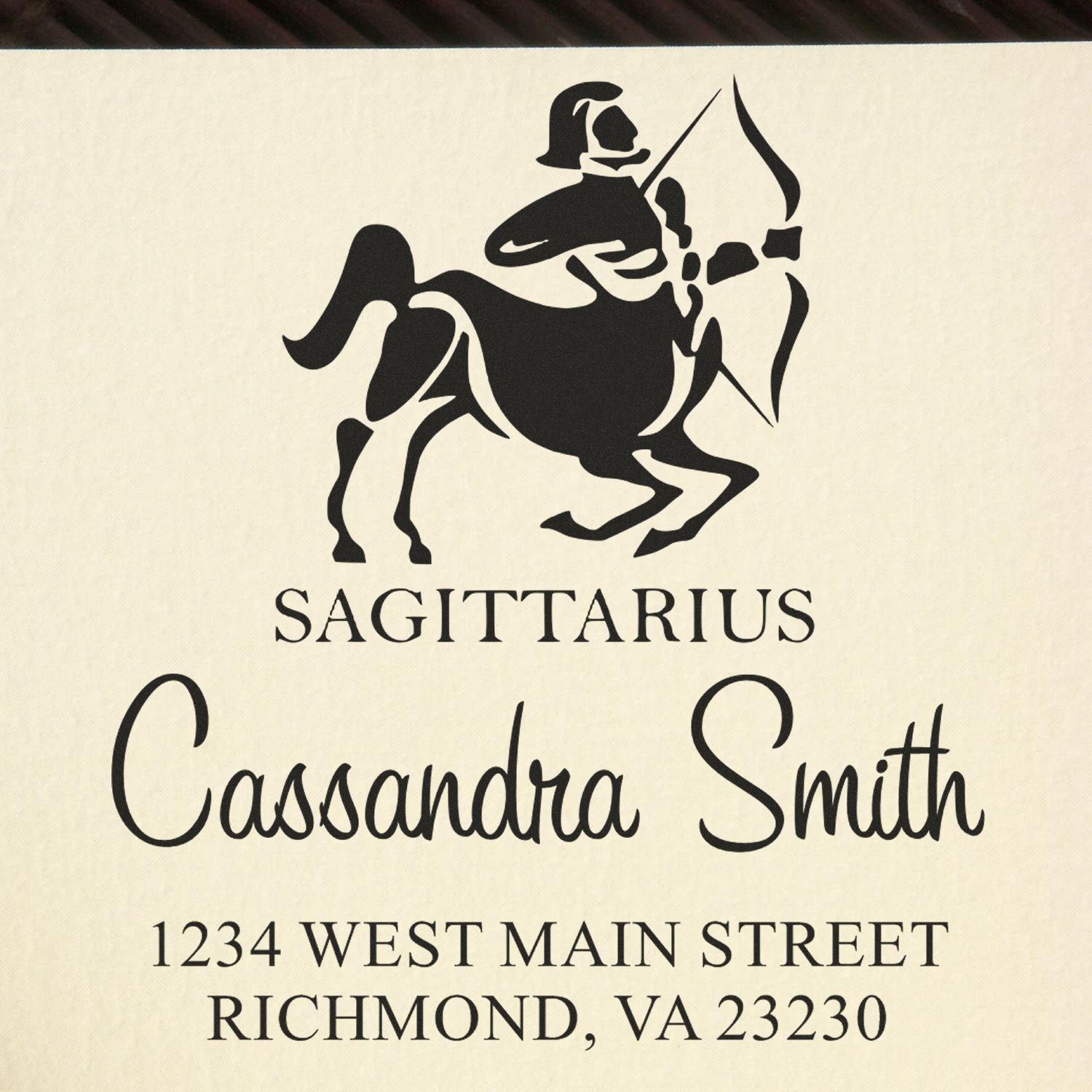 Black Sagittarius stamp seal with centaur archer on cream background, featuring Cassandra Smith and Richmond, VA address.