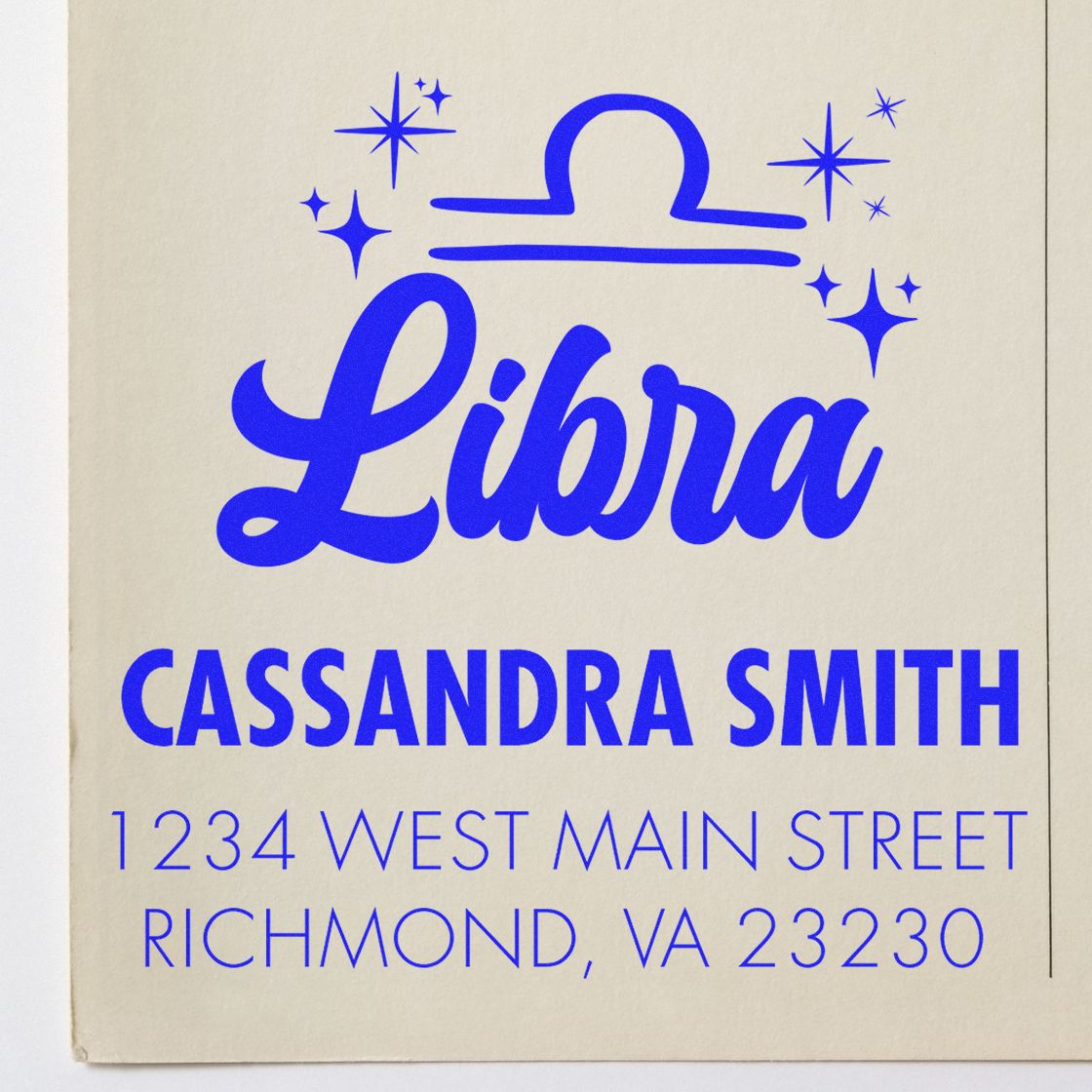 Blue Libra stamp and seal design with sparkles, Cassandra Smith name and address on cream background.